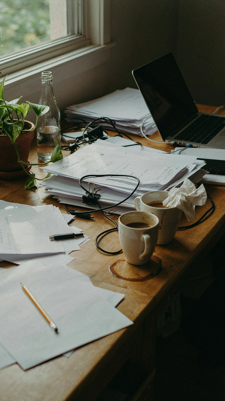 A messy desk with many papers and objects, showing visual clutter.