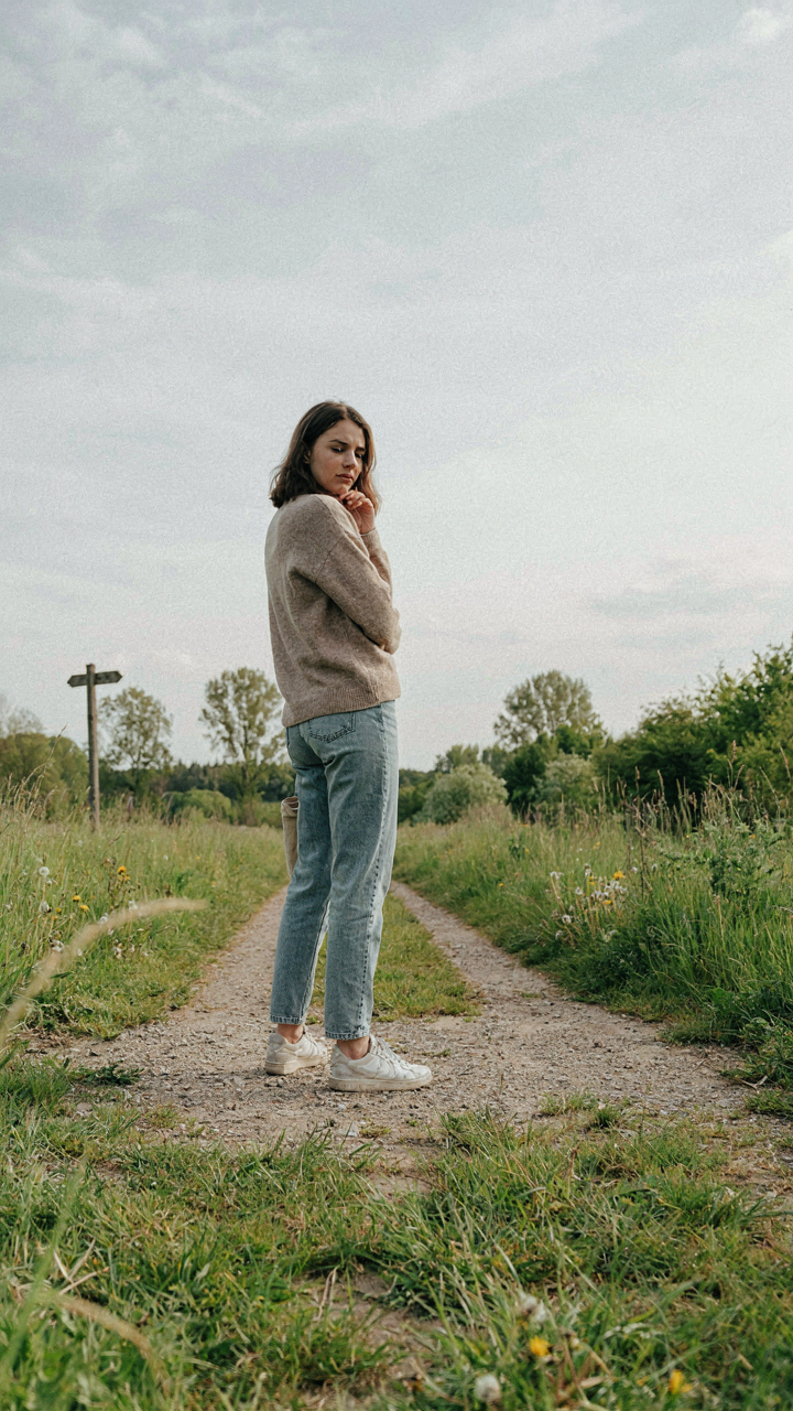 A person stands at a crossroads, looking unsure.
