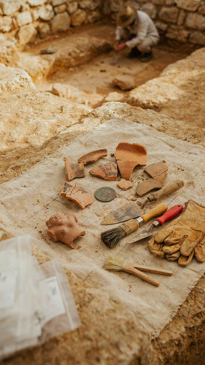 An archaeological dig site with ancient artifacts laid out.