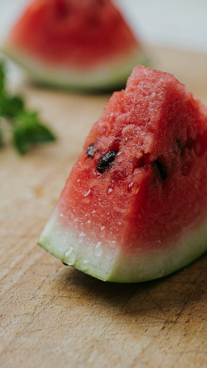 A cold, freshly cut watermelon slice shows condensation.