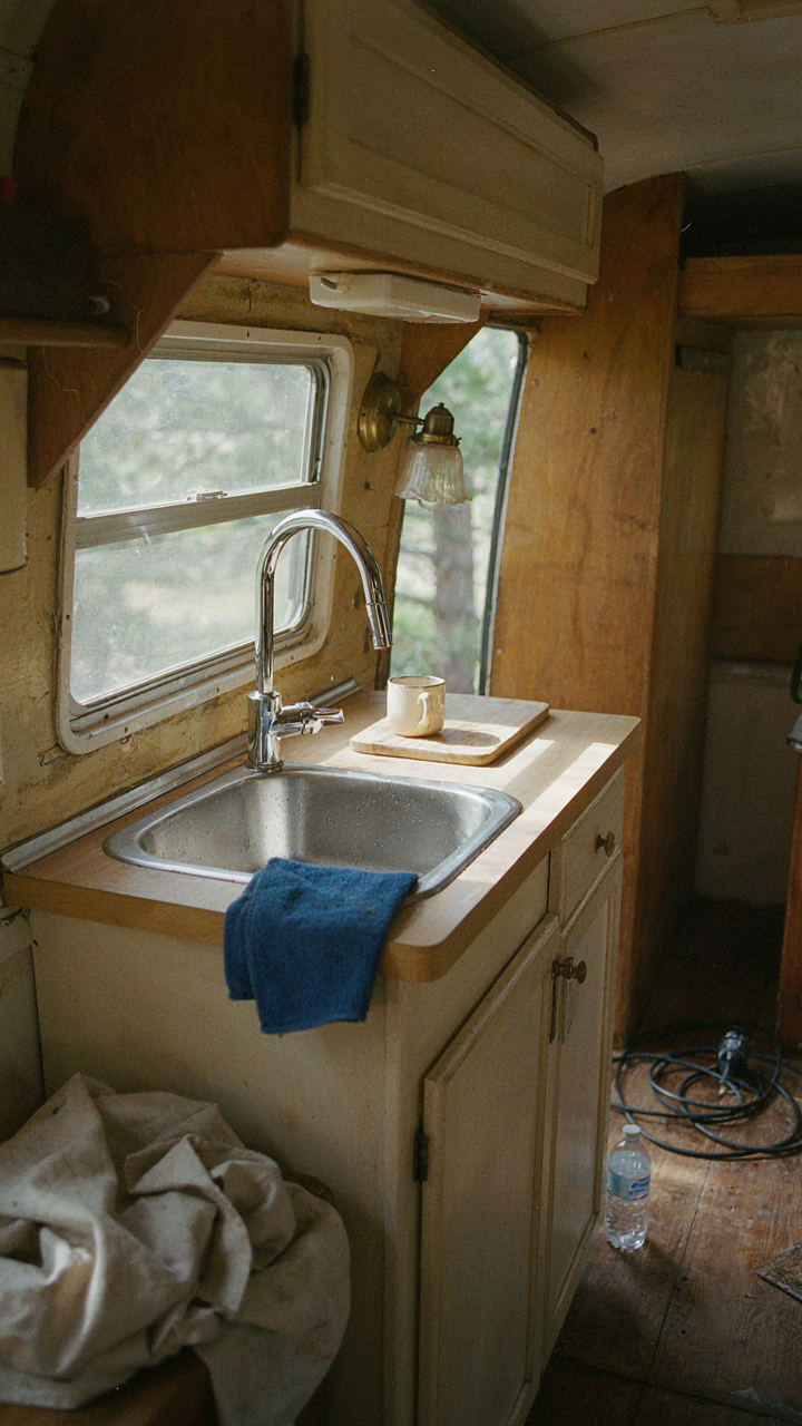 A shiny new kitchen sink and faucet inside a vintage camper.