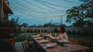 A beautiful twinkle light canopy glows over a backyard patio at dusk.