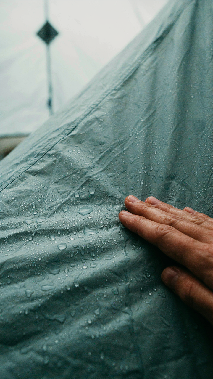 Water drops form inside a cold tent wall.