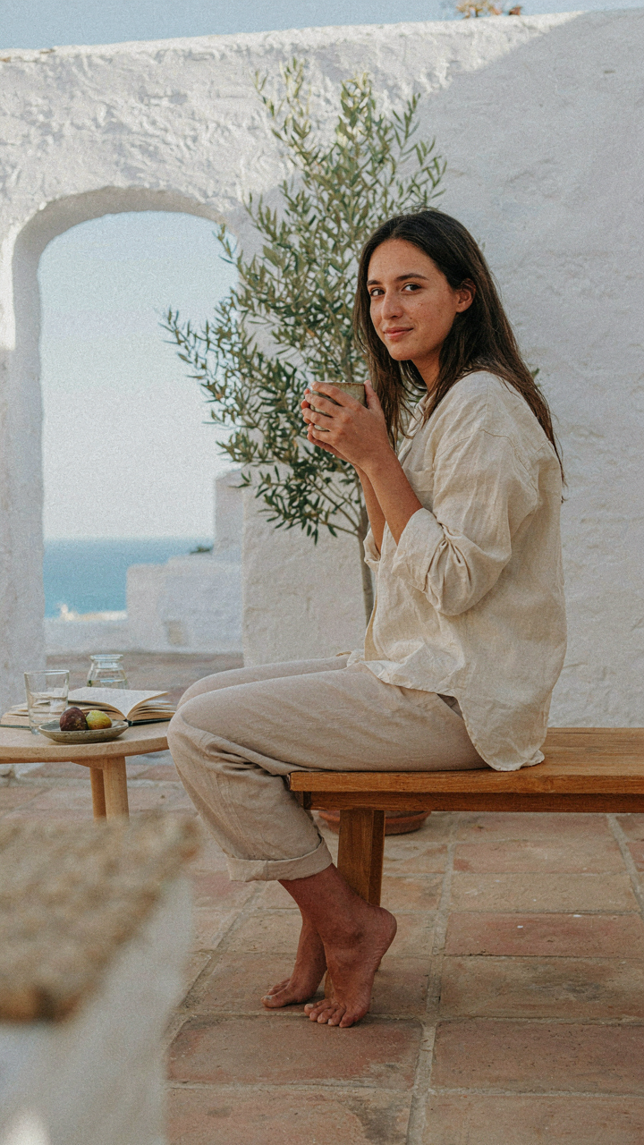 A person sitting alone on a well-designed patio, enjoying a quiet moment. It is cozy patio decor.